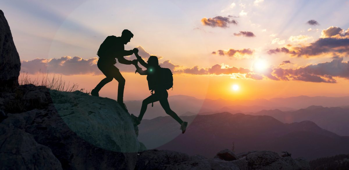 concept of male climber helping his girlfriend and moments of success together