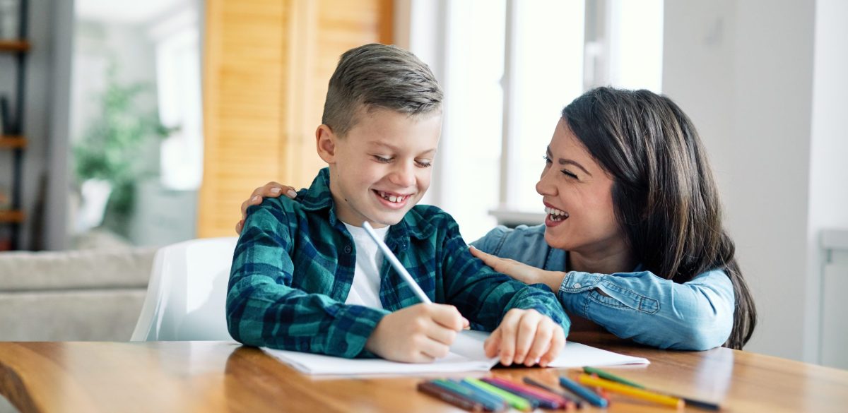 mother teaching sons and helping with homework at home